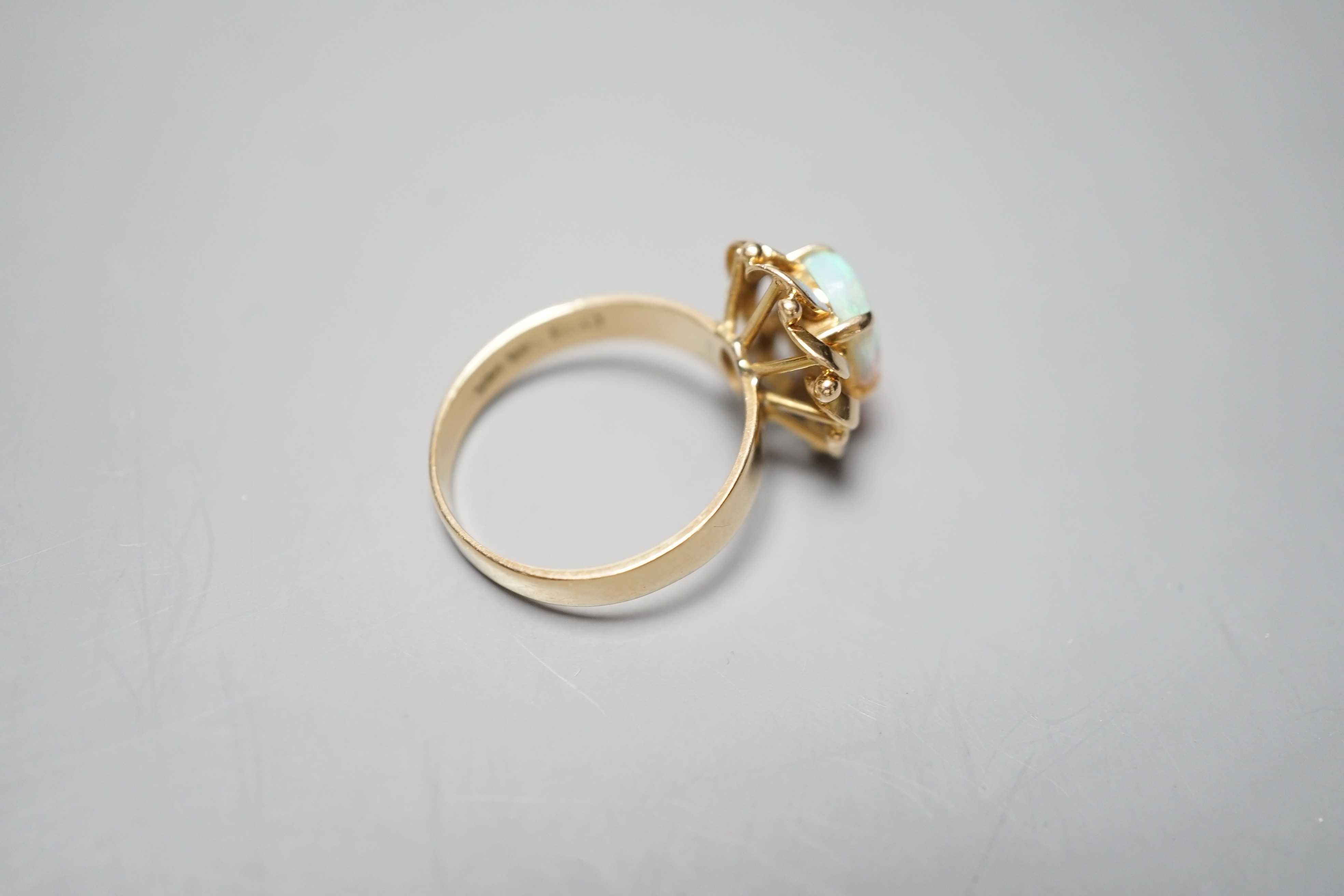 A 14k yellow metal and white opal set oval dress ring, size O, gross weight 3.9 grams.